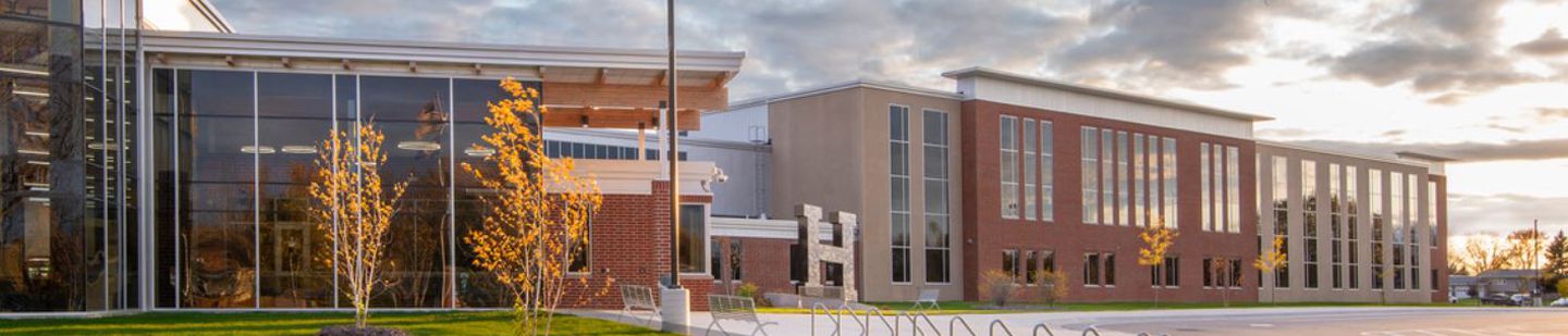 Wide shot of Hutchinson High School with a cloudy sky in the background