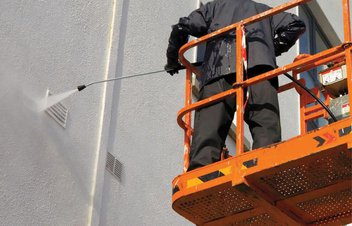 worker washing a building