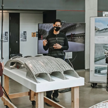 students presenting posters and project models to academics and industry professionals