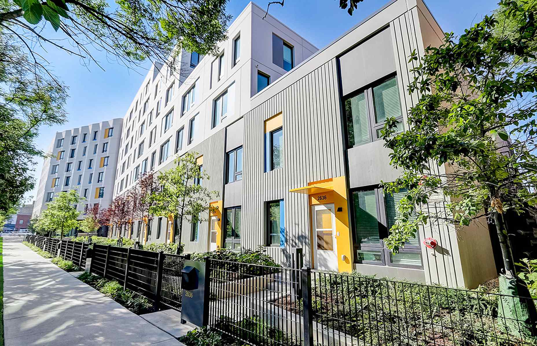 corner view of lucy gonzales parsons apartments showing a formliner finish and stained concrete