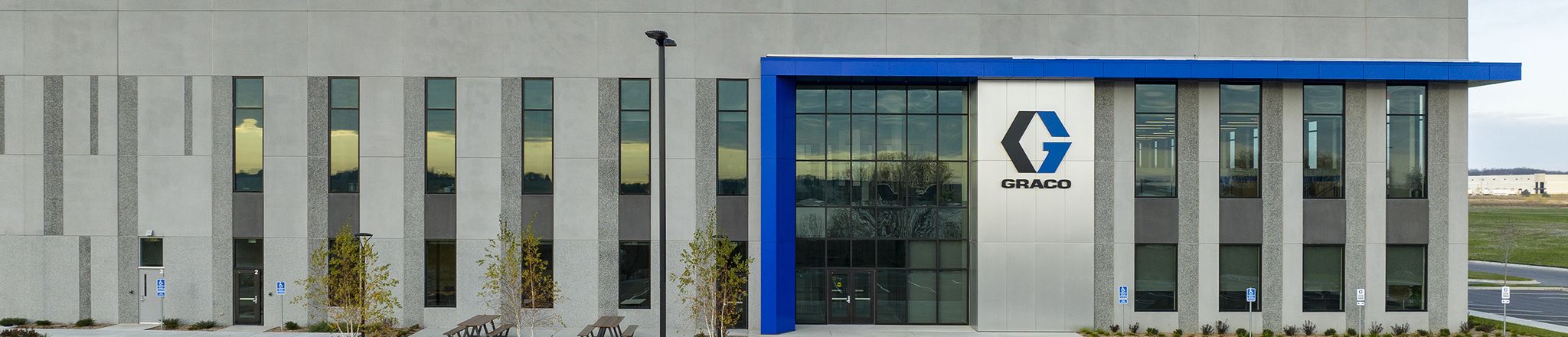 entrance of graco distribution center with sky and parking lot