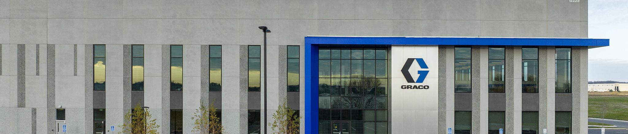 entrance of graco distribution center with sky and parking lot