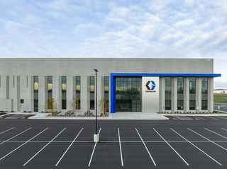 entrance of graco distribution center during the day with sky and parking lot