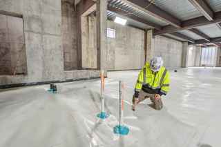 worker applying sealants in basement of warehouse